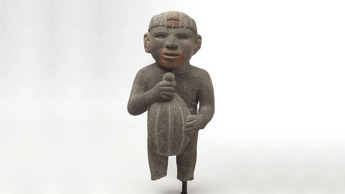 Mali kameni kip koji u svojim rukama drži kakao plod