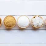 Fotografija sa posudicama u kojima stoje različite vrste šećera.