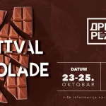 Najava za Festival čokolade na Dorćol placu. Braon pozadina sa lomljenom čokoladom.
